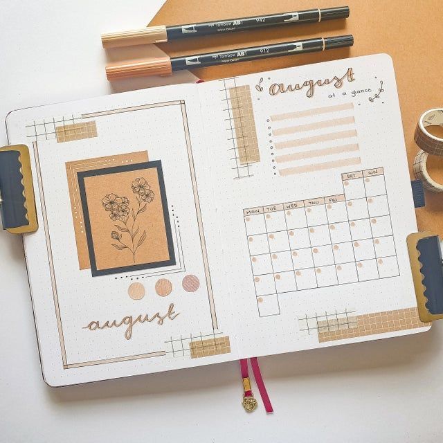 an open planner book sitting on top of a desk next to a cup of coffee