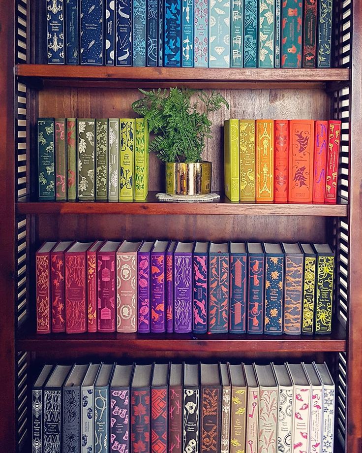 a wooden book shelf filled with lots of books and a potted plant on top of it