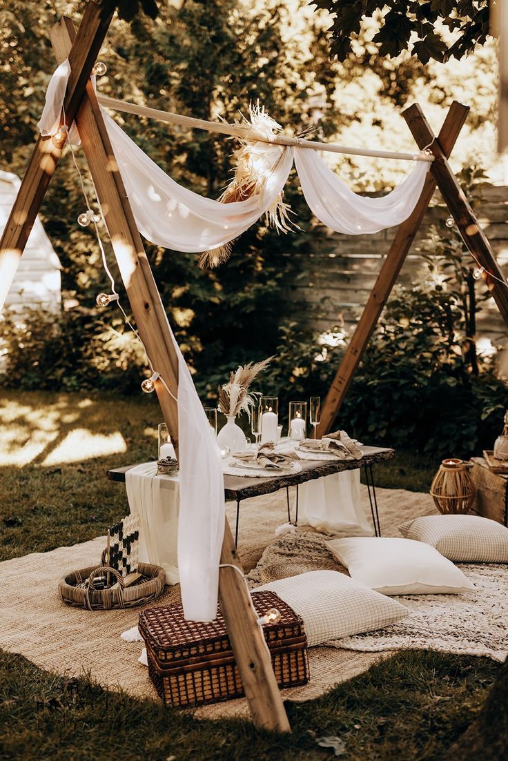 an outdoor picnic setting with white linens and pillows