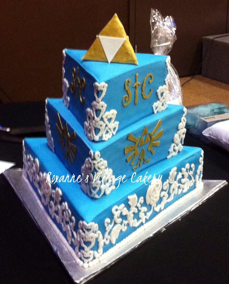 three tiered blue cake with white and gold decorations