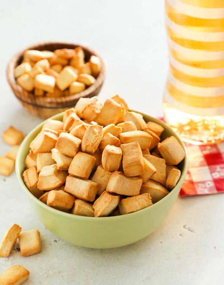 two bowls filled with small pieces of food next to each other on top of a table