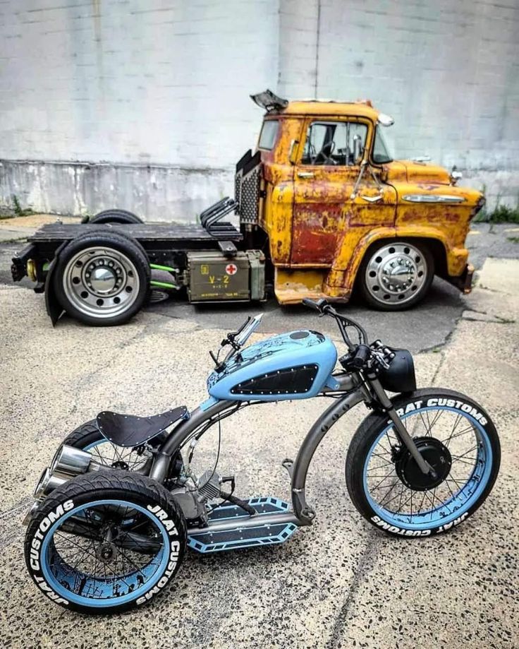 a blue and black motorcycle parked next to a yellow truck