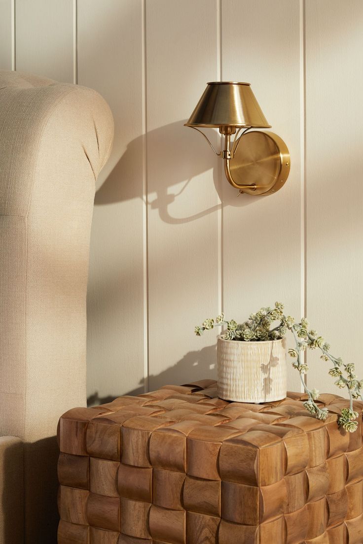 a small potted plant sitting on top of a wooden table next to a chair