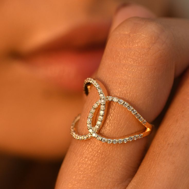 a woman's hand with a diamond ring on her finger and an open gold band