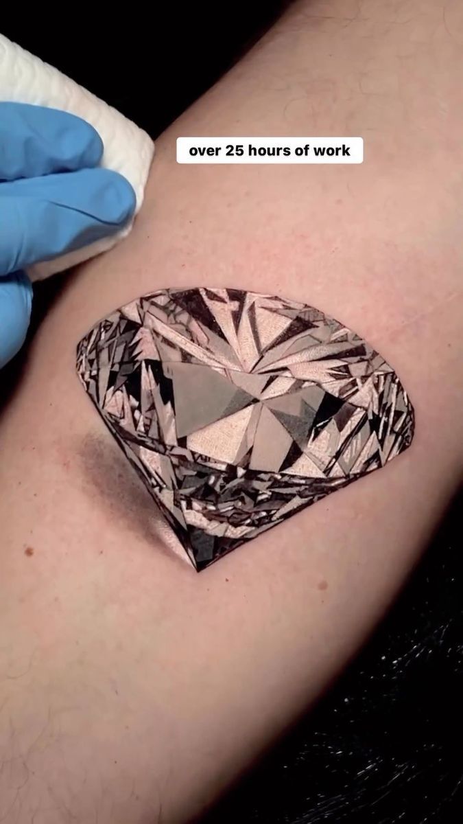 a person with blue gloves on their arm holding a diamond tattoo