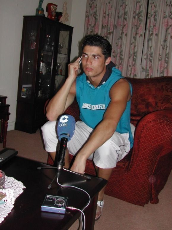 a young man sitting on top of a couch next to a table with a microphone