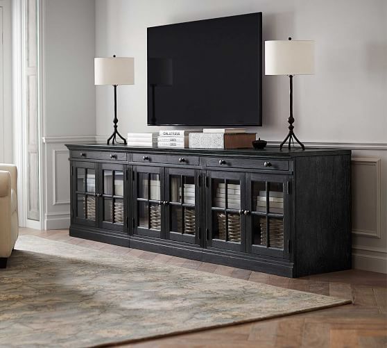 a living room with a large flat screen tv on top of a wooden entertainment center