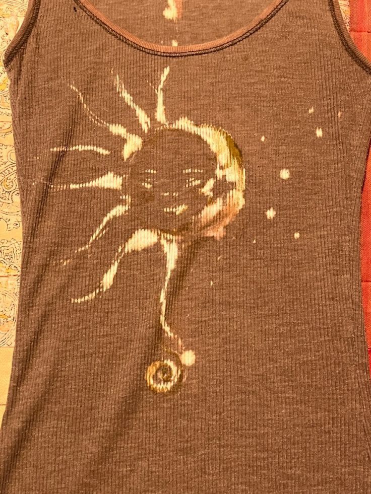 a brown tank top with an image of a sun on it