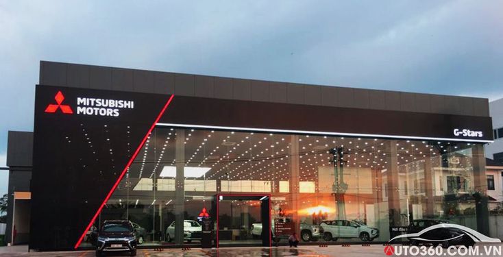 a car dealership with several cars parked in front of it and the words mitsubishi motors written on the side