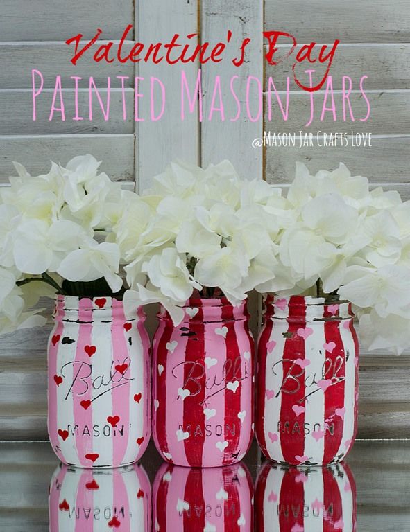 three red and white striped jars with flowers in them