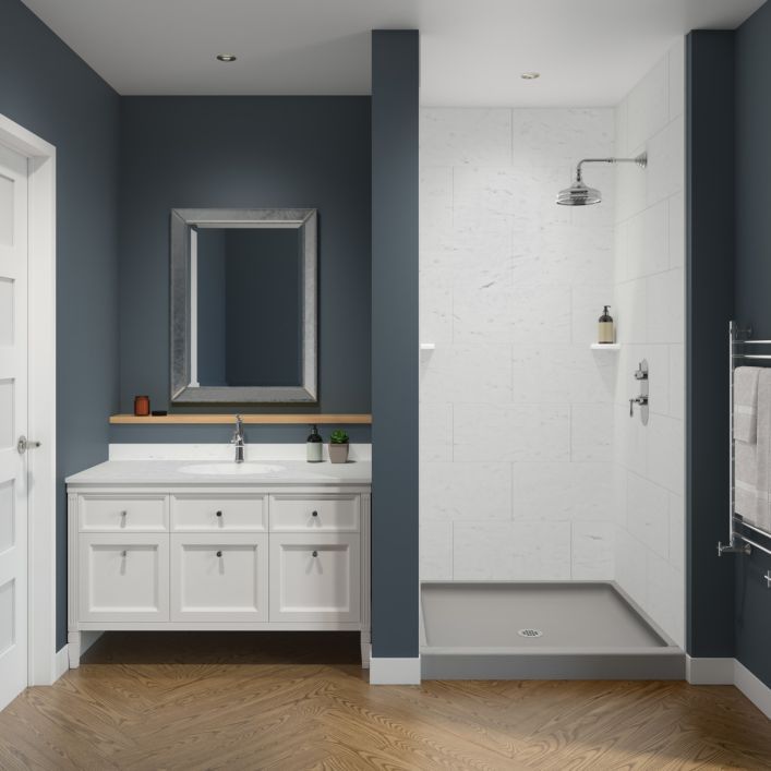 a bathroom with blue walls and white cabinets, wood flooring and a large mirror on the wall