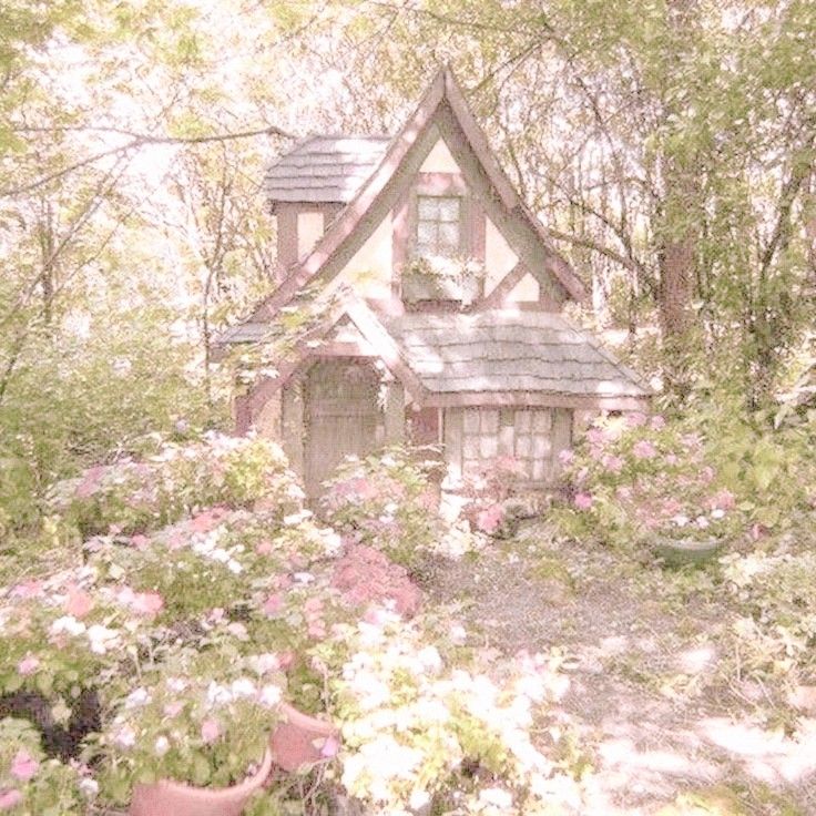 a small house surrounded by flowers and trees