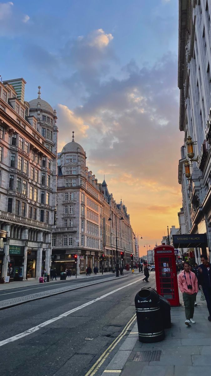 a city street lined with tall buildings at sunset