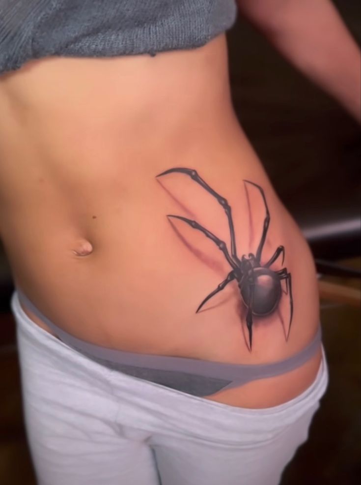 a woman with a spider tattoo on her stomach