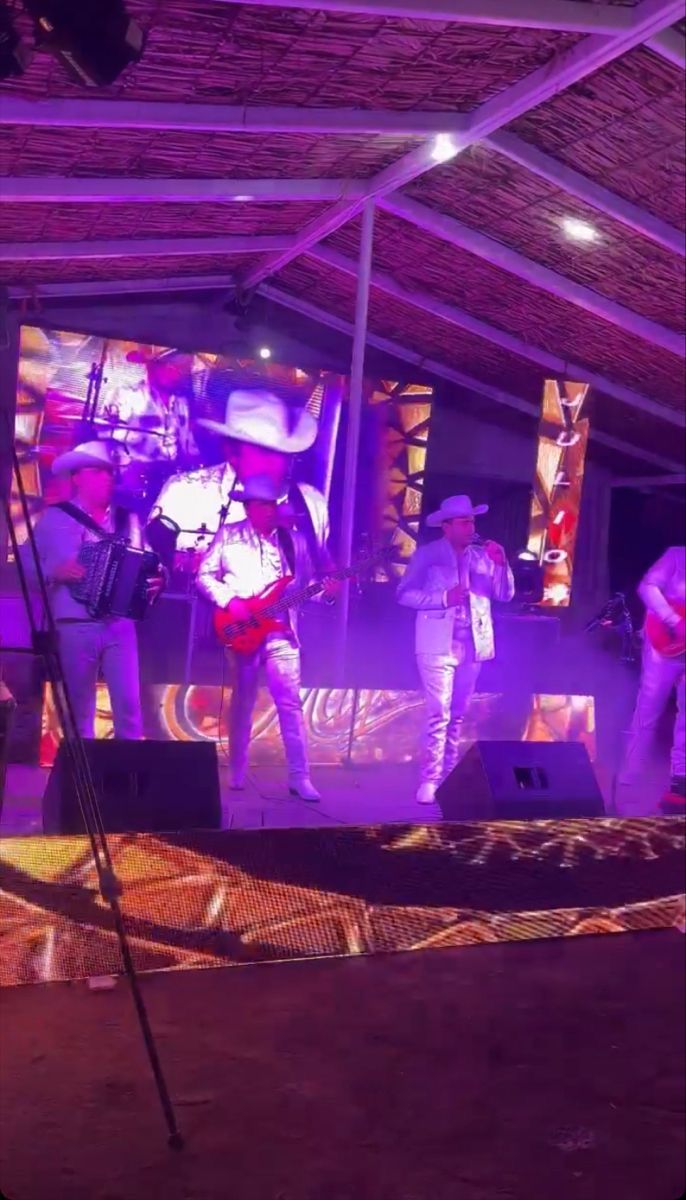 a group of people that are standing in front of a stage with lights on it