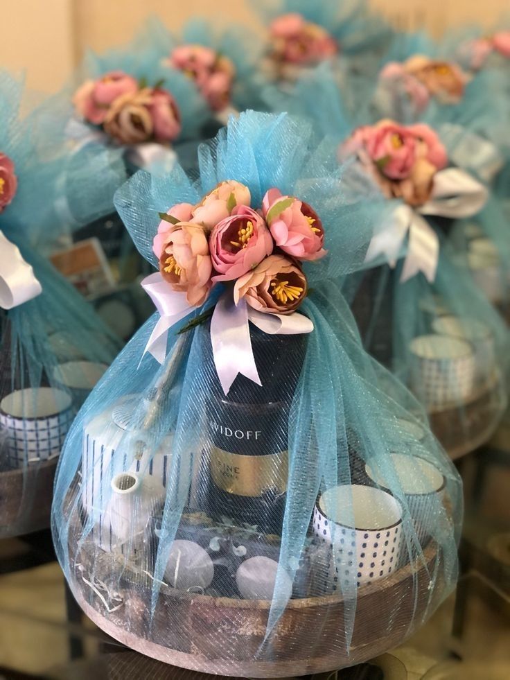 several bottles of wine wrapped in blue organes with bows and flowers on the top