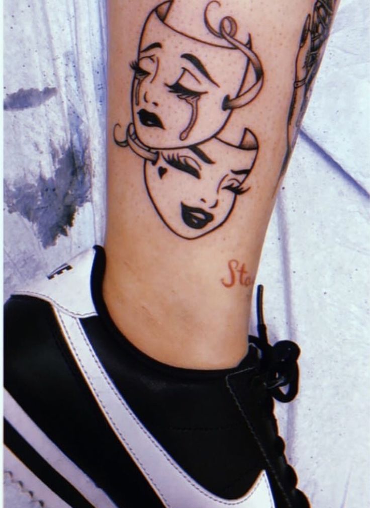 a woman's leg with a black and white tattoo design on her left calf