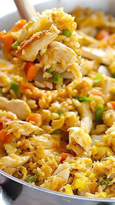 a close up of food in a pan with a wooden spoon