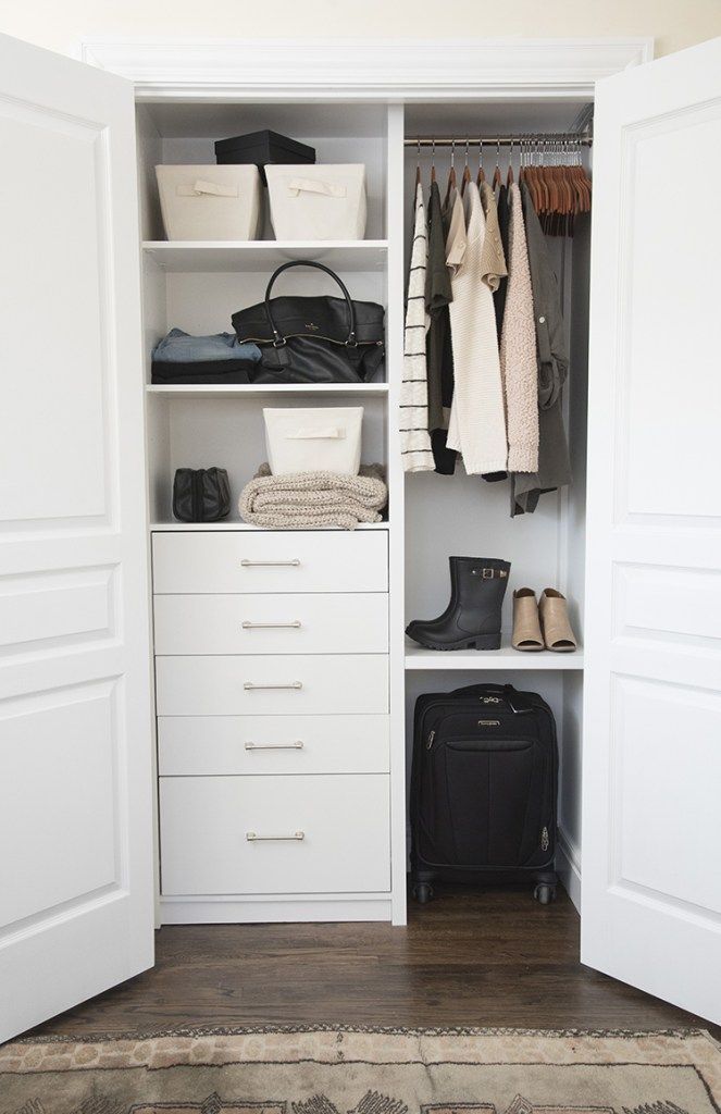 an image of a closet with clothes and bags on the shelves in front of it