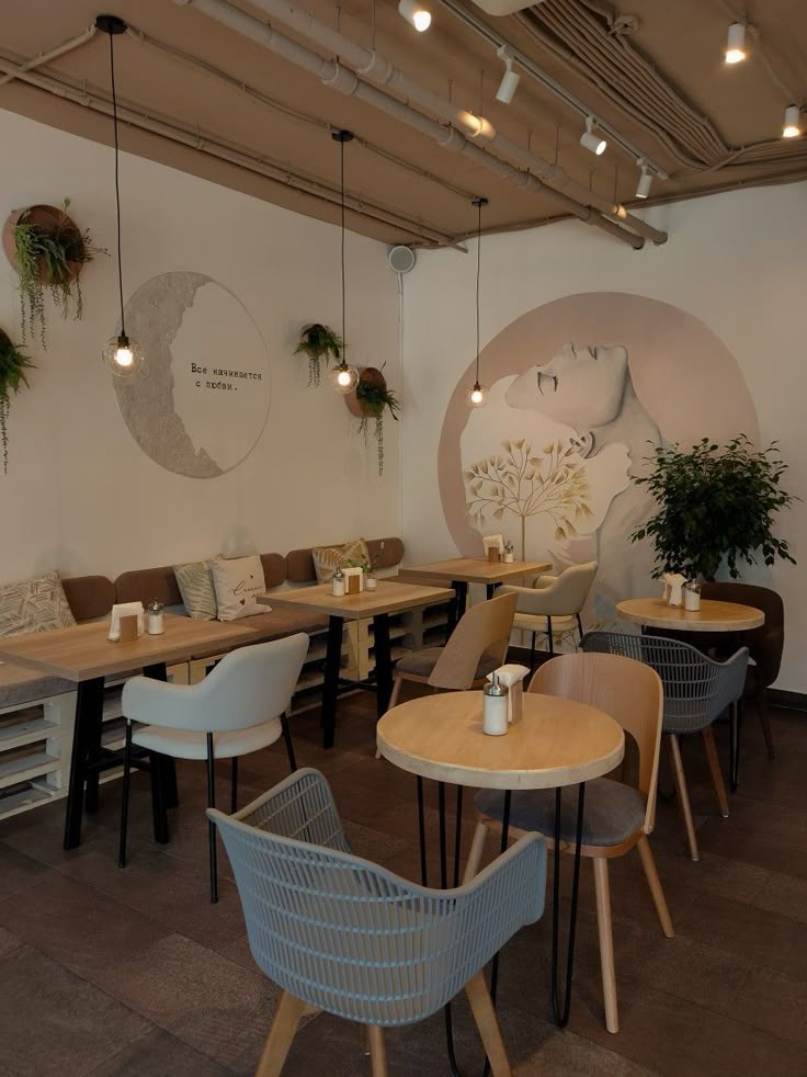 the interior of a restaurant with tables, chairs and plants on the wall behind them