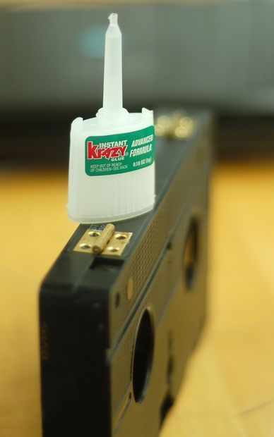 a black box with a white container on top of it sitting on a wooden table