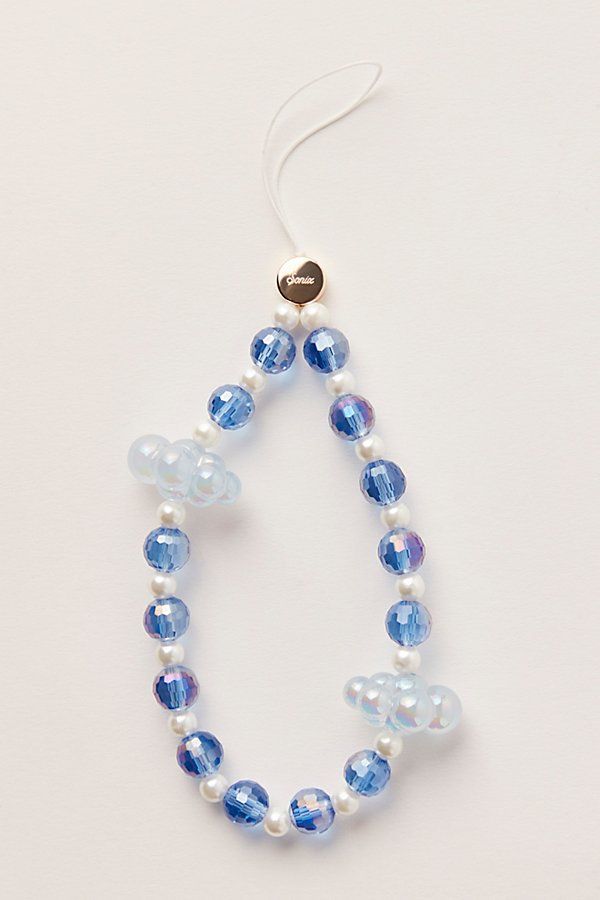 a necklace with blue and white beads hanging from it's side on a white surface