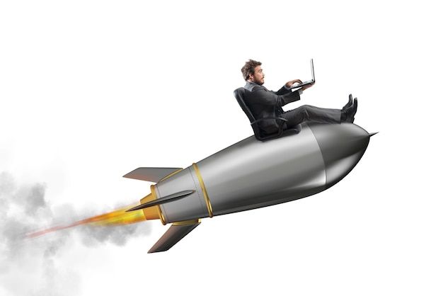 a man sitting on top of a rocket with a laptop in his lap while flying through the air