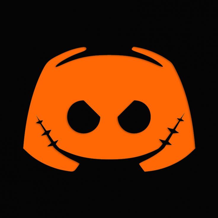 an orange pumpkin with black eyes and two horns on it's head, in the dark