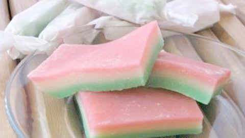 three pieces of watermelon are on a glass plate next to cotton swabs