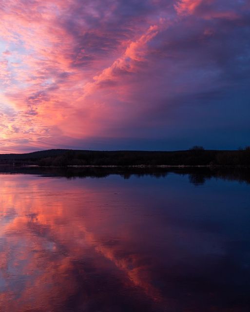 the sky is reflecting in the water at sunset