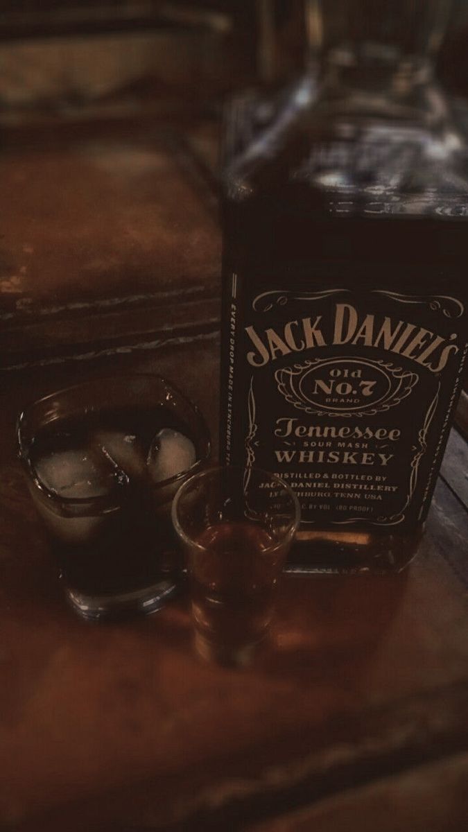 a bottle of jack daniels sitting on top of a wooden table