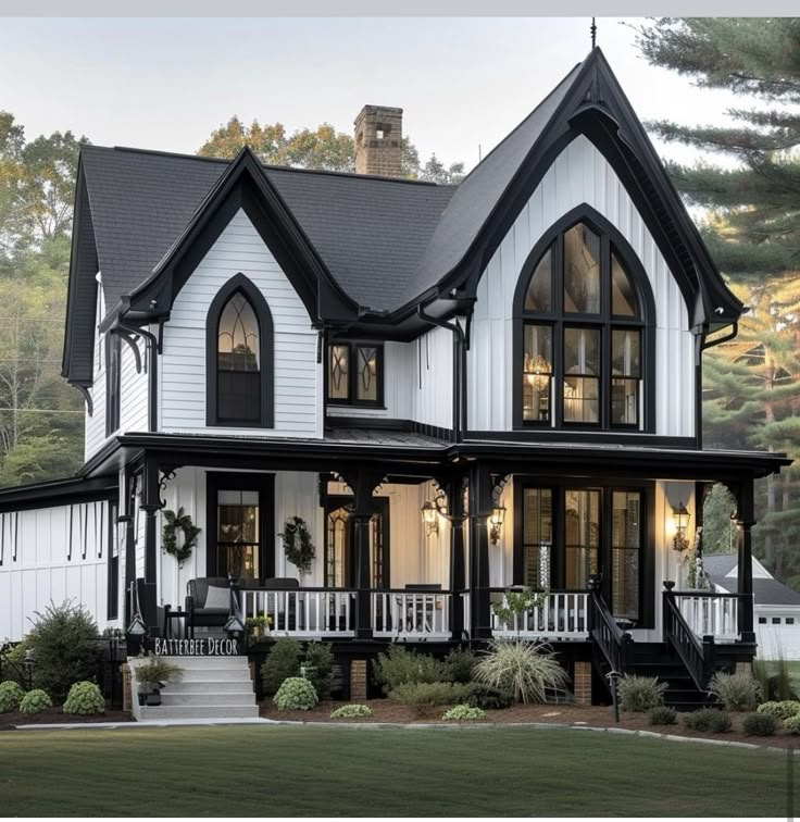 a large white house with black trim and lots of windows on the second story,