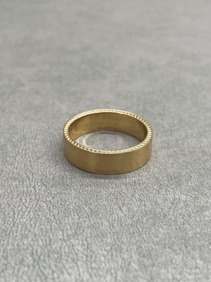 a gold ring sitting on top of a gray surface