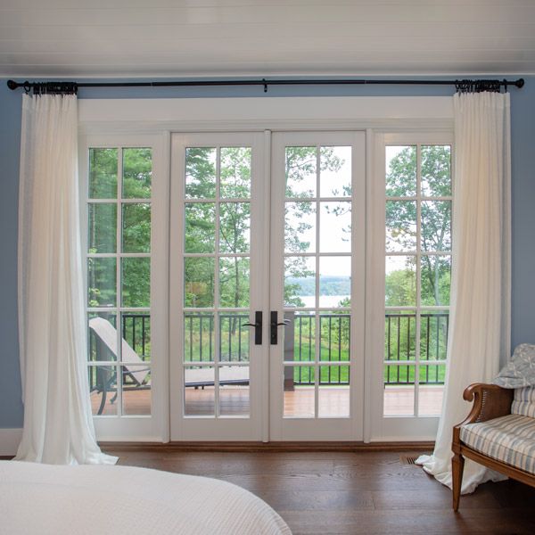 a bedroom with french doors leading to a balcony