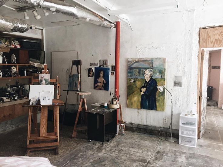 an artist's studio with paintings on the wall