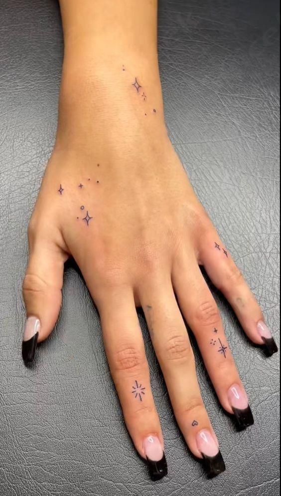 a woman's hand with small stars on her left and right thumbnails