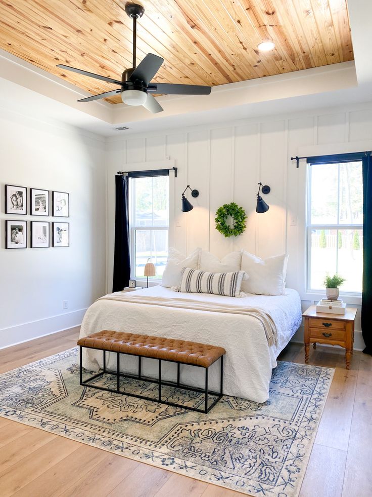 a bedroom with white walls and wood ceiling