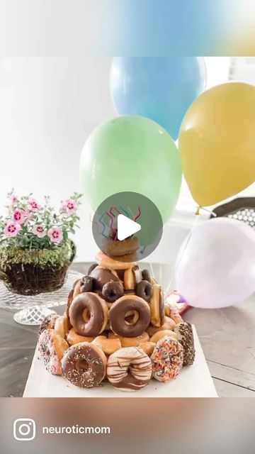 a birthday cake with donuts and balloons