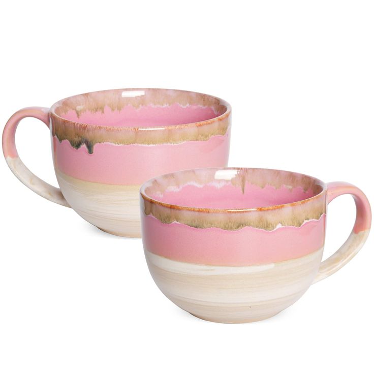 two pink and white coffee cups sitting next to each other