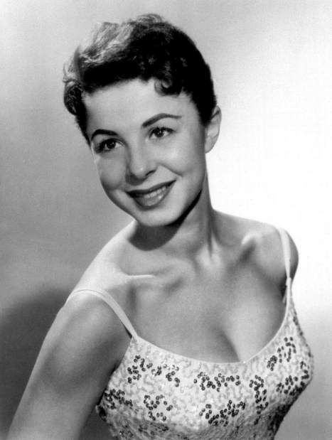 an old black and white photo of a woman in a tank top smiling at the camera