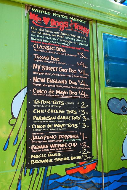 a menu board on the side of a food truck with cartoon characters painted on it