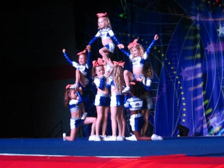 a group of cheerleaders standing on top of each other in front of a stage