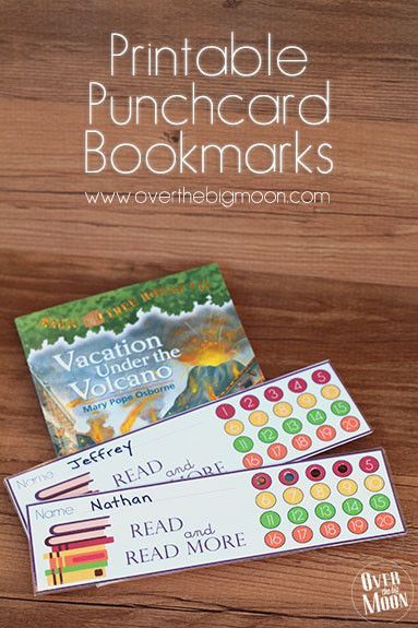 the printable punch card bookmarks are sitting on top of a wooden table next to some books