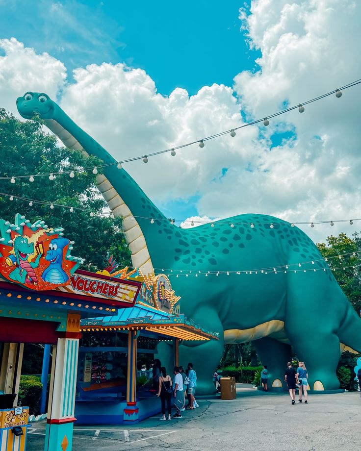 an amusement park with a large dinosaur statue