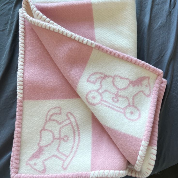 a pink and white blanket with an image of a dog on it's side