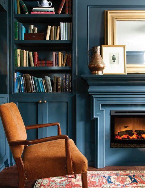 a living room with a fireplace and bookshelf filled with shelves full of books