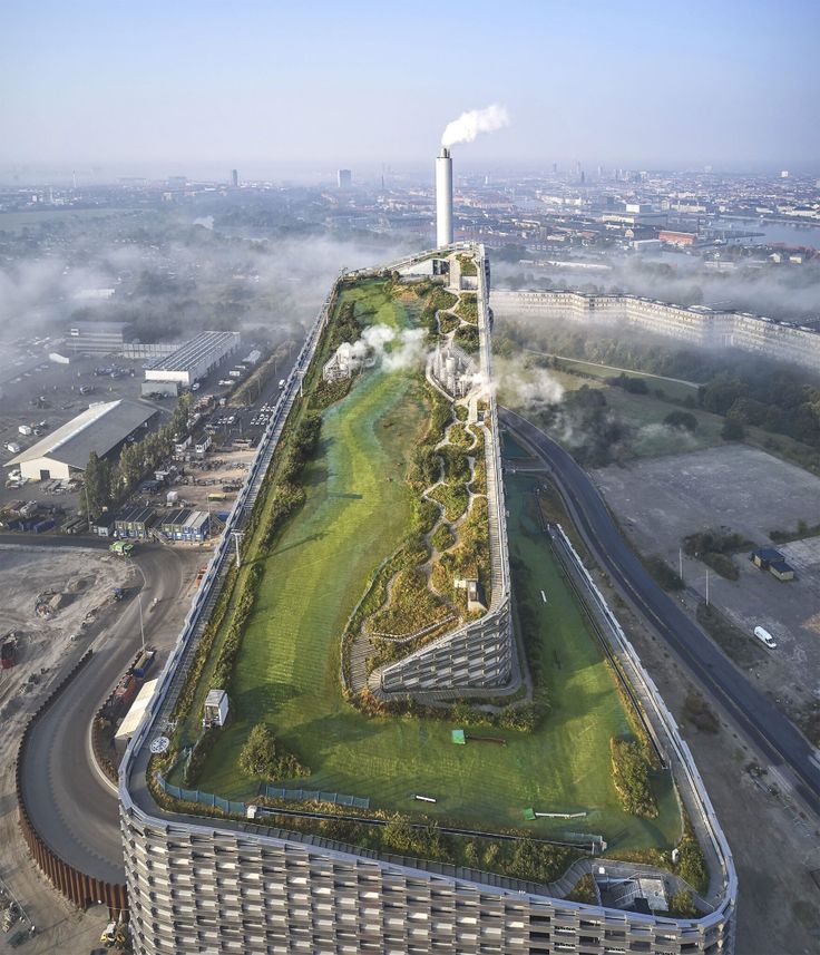 an aerial view of a large building with a green roof and grass on the top