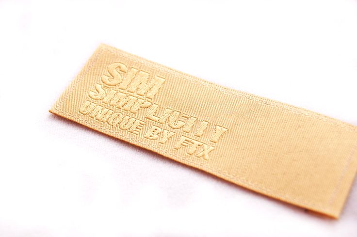 a close up of a gold colored label on a white surface with the words simplaced by it