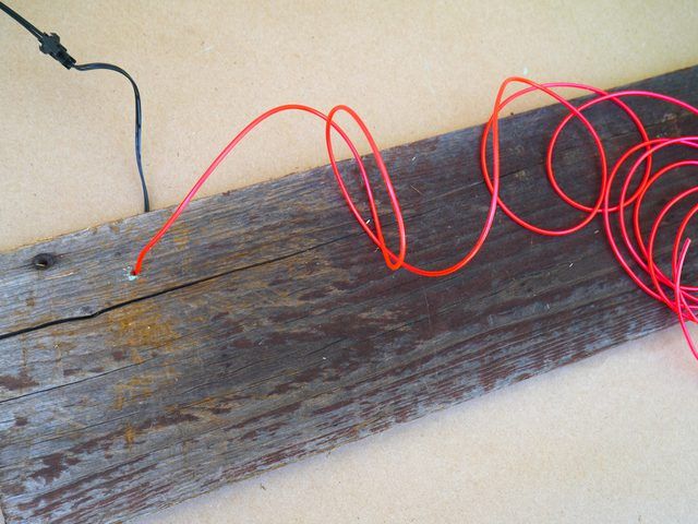 some red wires are on top of a piece of wood