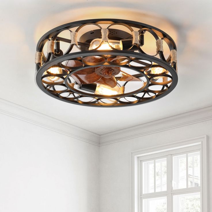 a round light fixture hanging from the ceiling in a room with white walls and windows